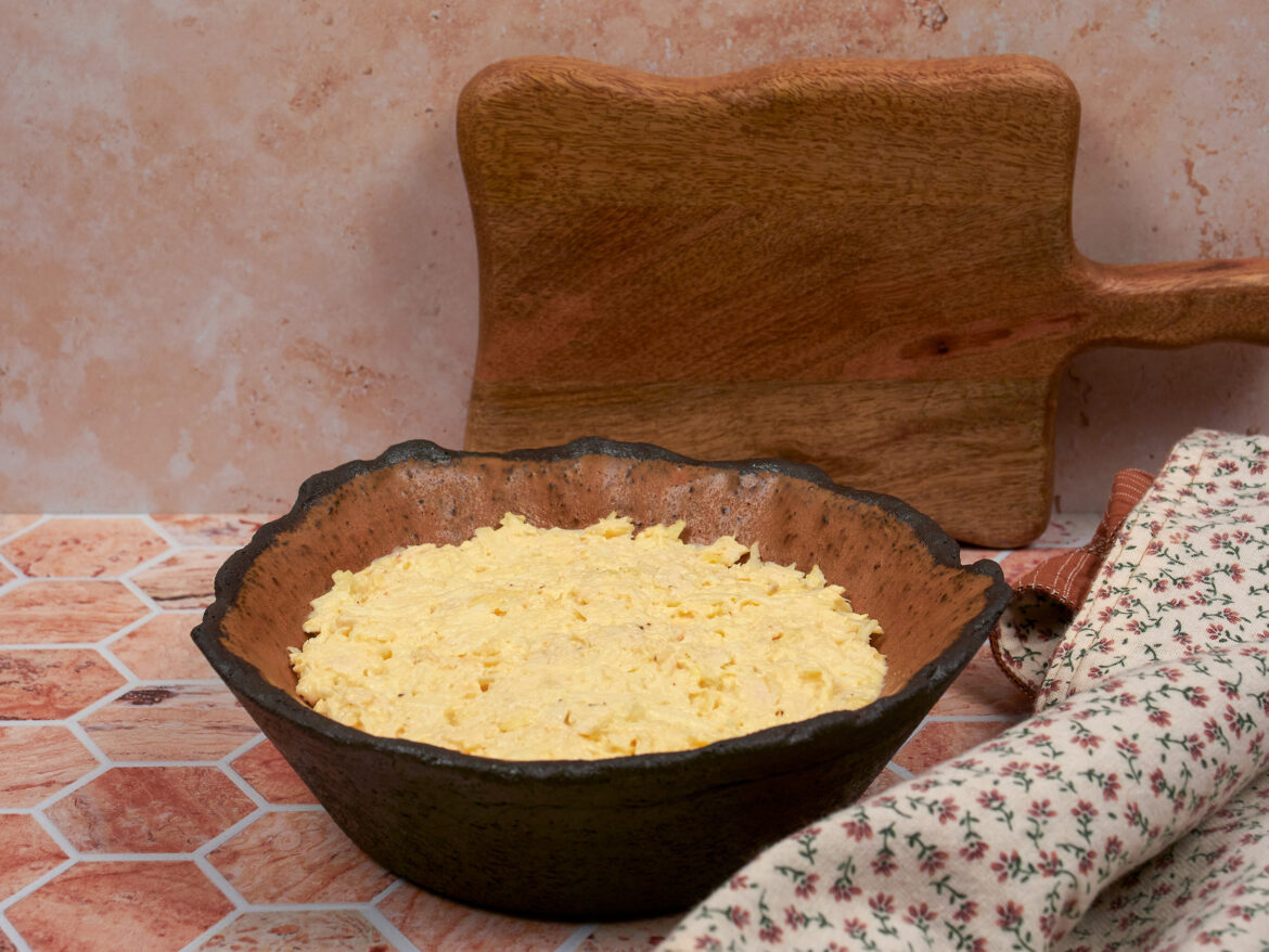 Salată de țelină cu pui, într-un bol de ceramic.ă neagră